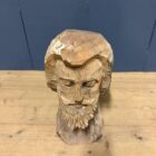 Uit hout gesneden hoofd van een man met baard
