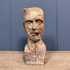 Oud verweerd uit hout gesneden hoofd