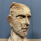 Oud verweerd uit hout gesneden hoofd