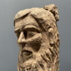 Verweerd gesneden houten hoofd van man met baard