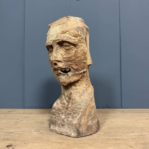 Oud verweerd uit hout gesneden hoofd